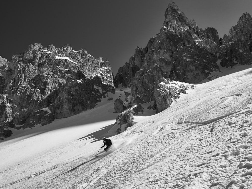 person riding on snow ski in grayscale photography