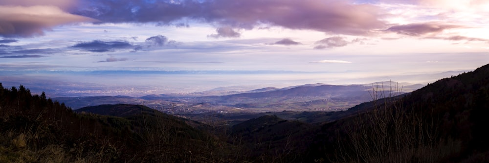 green and brown mountains under white clouds and blue sky during daytime