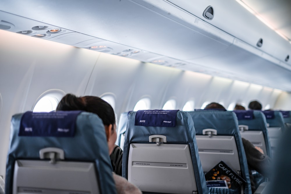 회색과 흰색 비행기 좌석에 앉아있는 사람들
