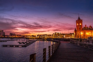 body of water near city buildings during sunset