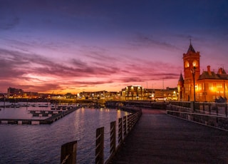 body of water near city buildings during sunset