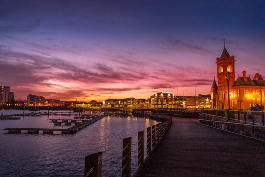 body of water near city buildings during sunset in Cardiff Bay United Kingdom