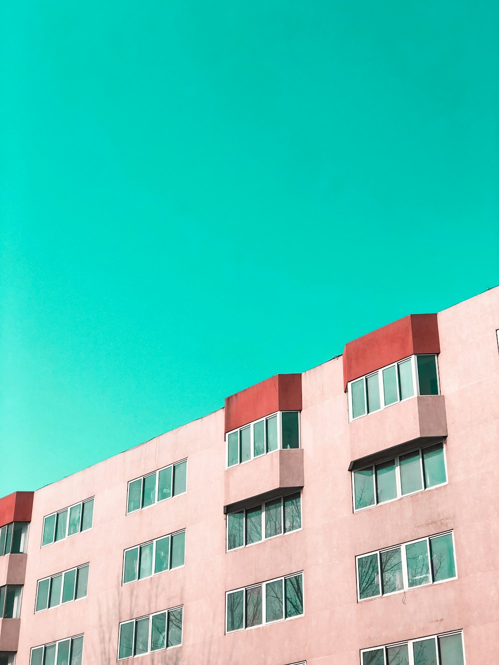 Edificio in cemento rosa sotto il cielo blu durante il giorno