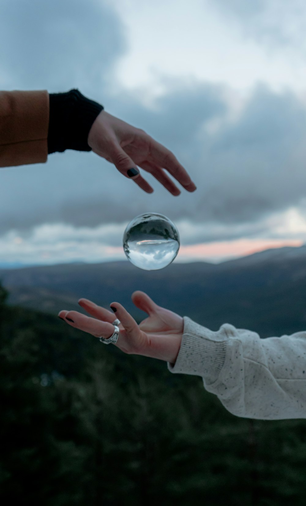 personne tenant une boule de verre transparent