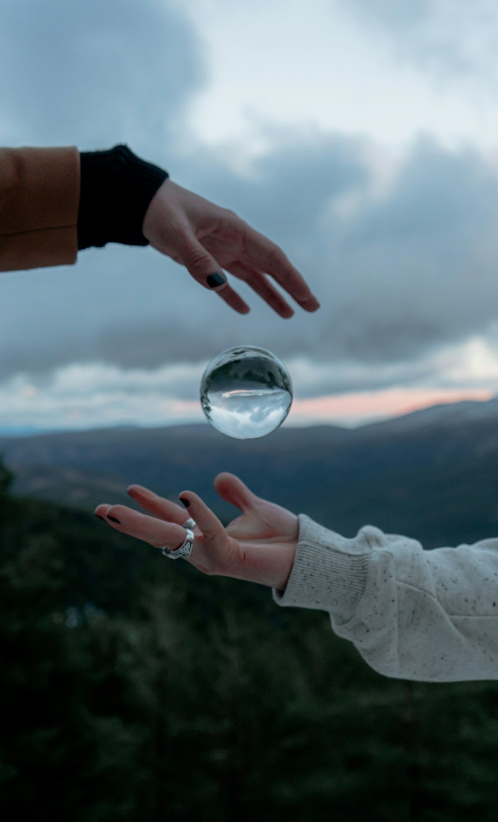 Persona sosteniendo una bola de vidrio transparente