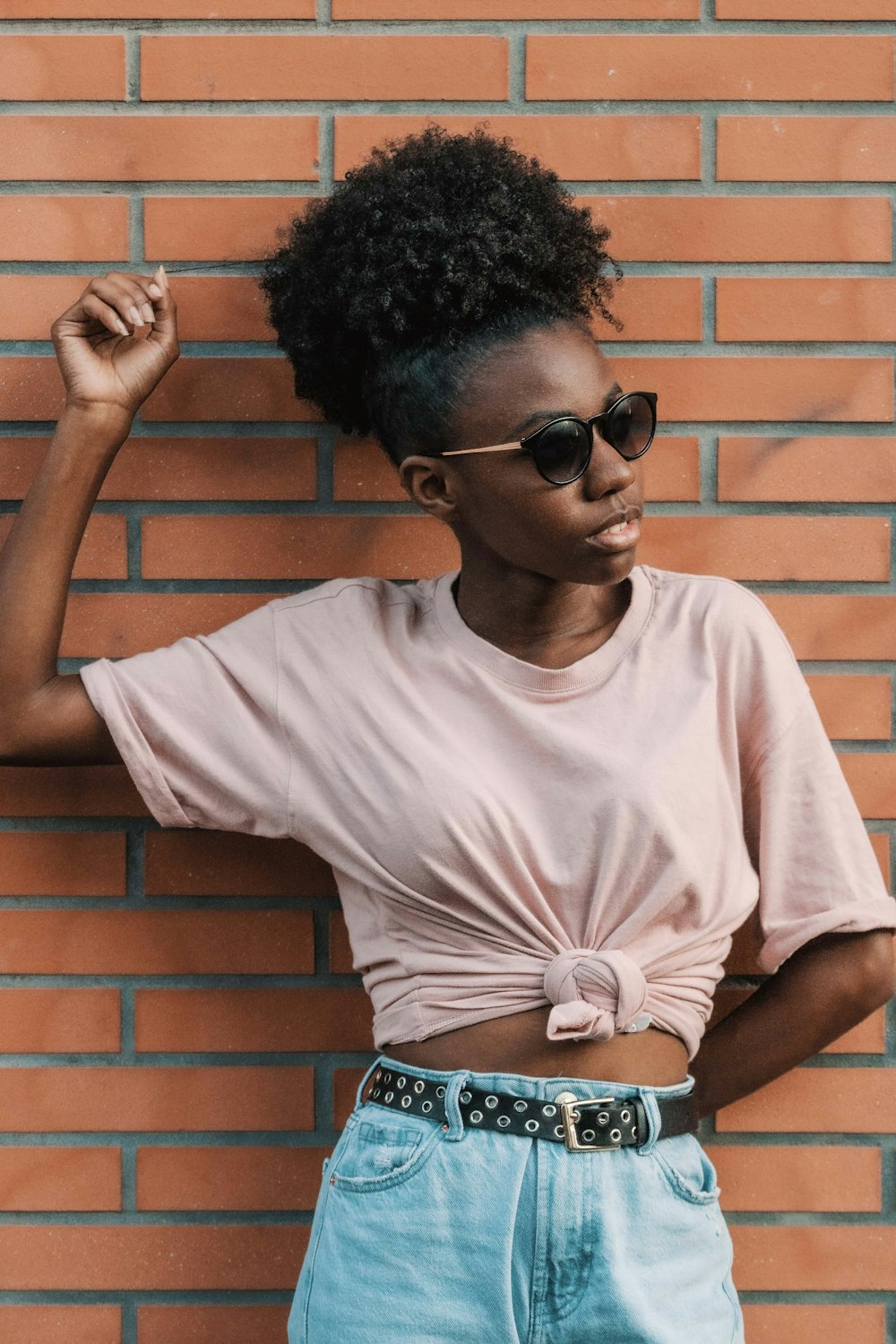 Femme en T-shirt blanc à col rond portant des lunettes de soleil noires