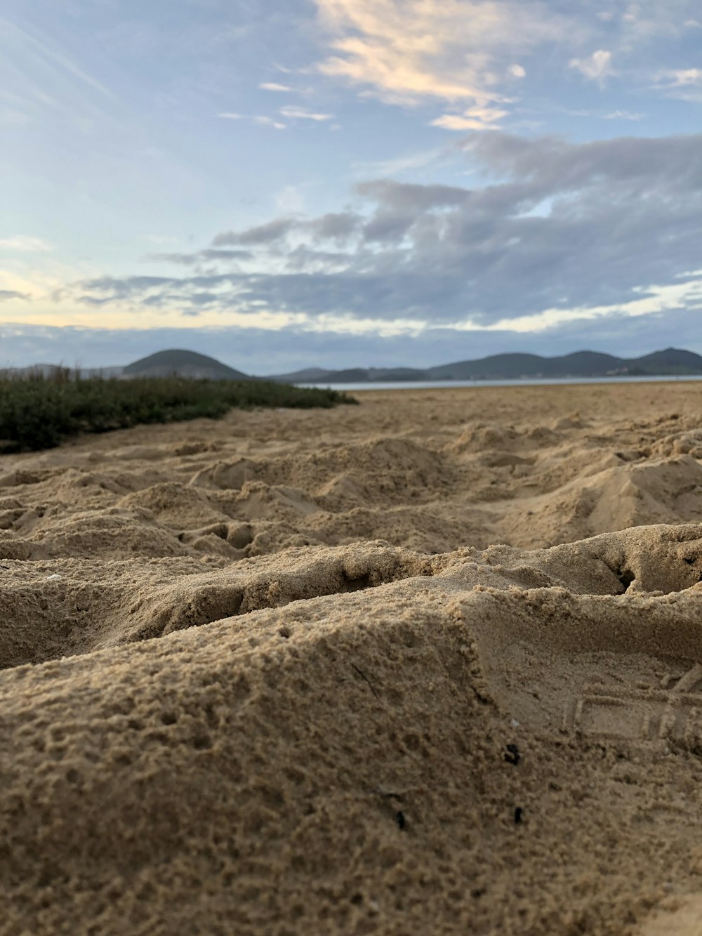 brown sand under white clouds during daytime