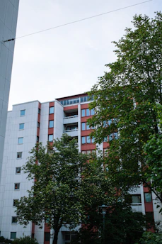 Cozy multifamily residential building surrounded by trees and green spaces.