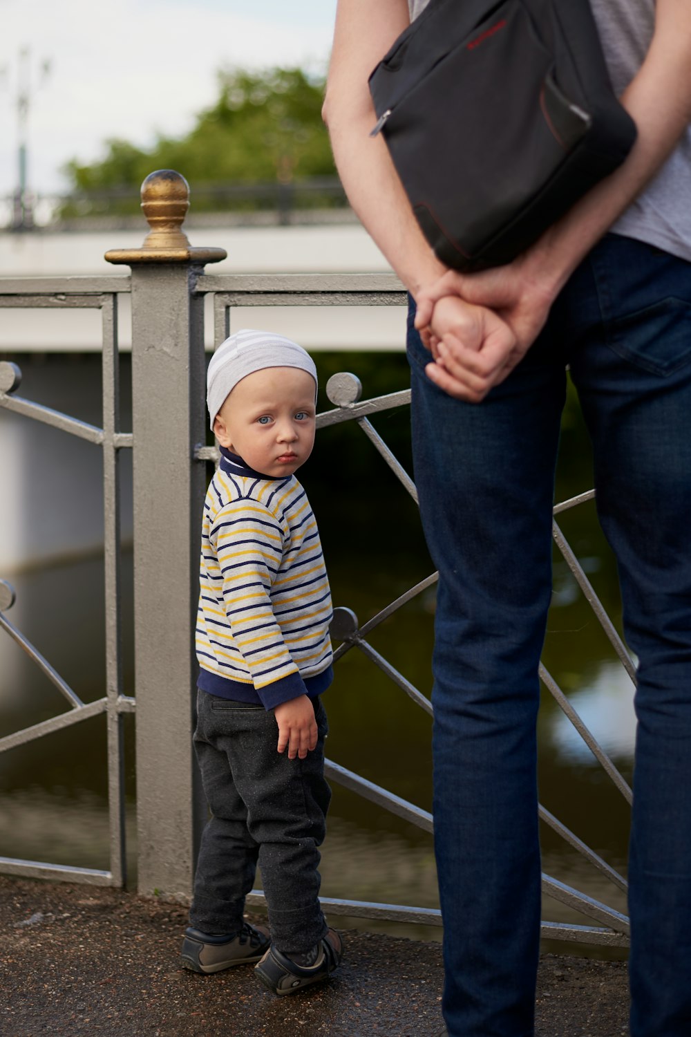 Mann im blau-weiß gestreiften Hemd trägt Baby im blau-weiß gestreiften Strampler