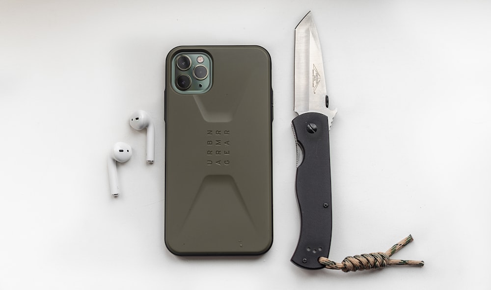 green iphone 5 c beside black and brown knife