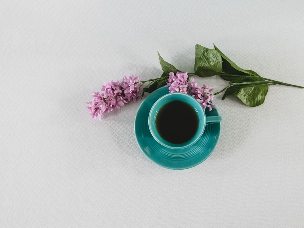 pink flower beside blue ceramic mug