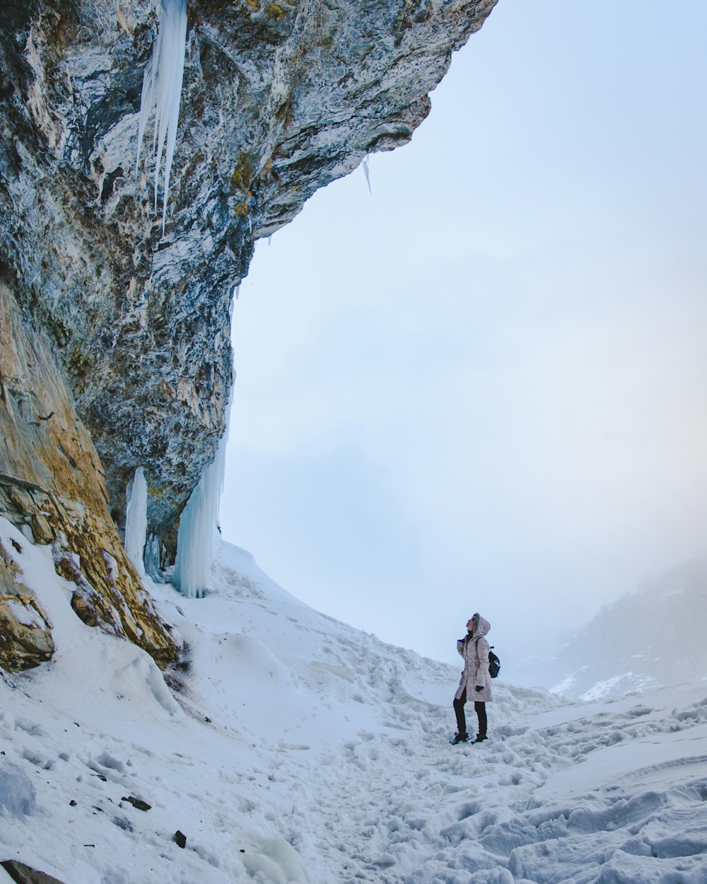 person in black jacket and black pants standing on snow covered ground during daytime