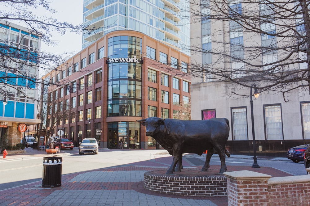 black cow statue on street during daytime