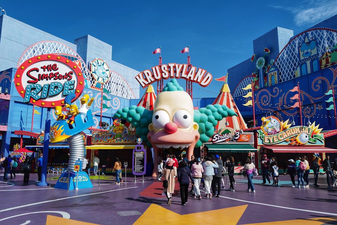 people walking around the park with red and white mickey mouse mascot