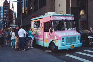 A vibrant smoothie truck parked under sunny skies with happy customers enjoying colorful drinks.