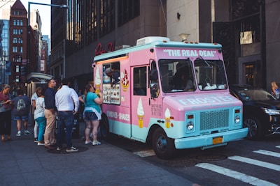 A colorful ice cream vending machine surrounded by happy employees enjoying a sweet treat during their break.