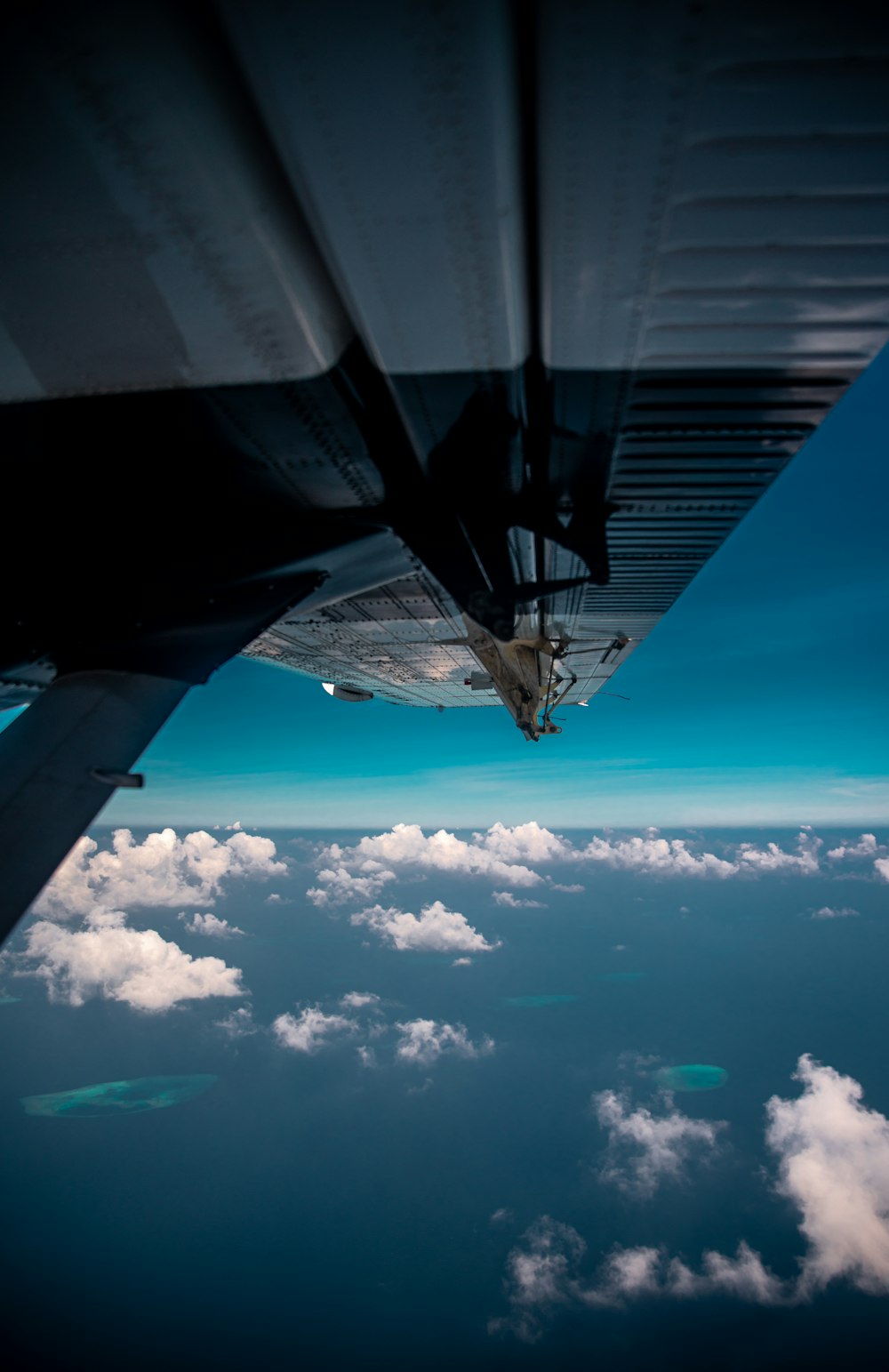 airplane flying over white clouds during daytime