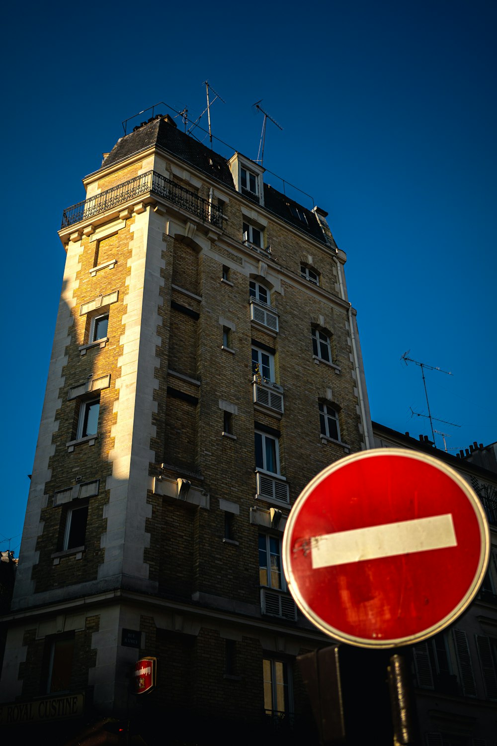 Edificio de hormigón marrón con letrero rojo y blanco de prohibido fumar