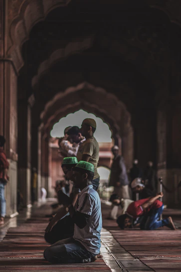 Close-up of hands raised in prayer inside the Grand Mosque, capturing a moment of devotion.