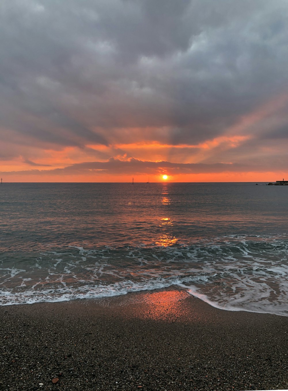 ocean waves crashing on shore during sunset