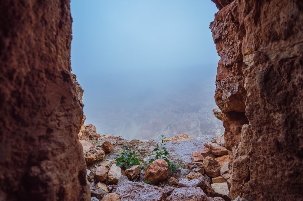 brown rocky mountain with fog during daytime