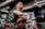topless man in black shorts carrying black dumbbell