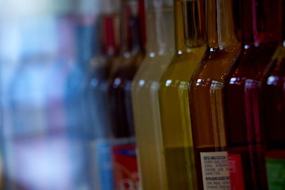 Various car wax bottles lined up with reflections on a glossy surface