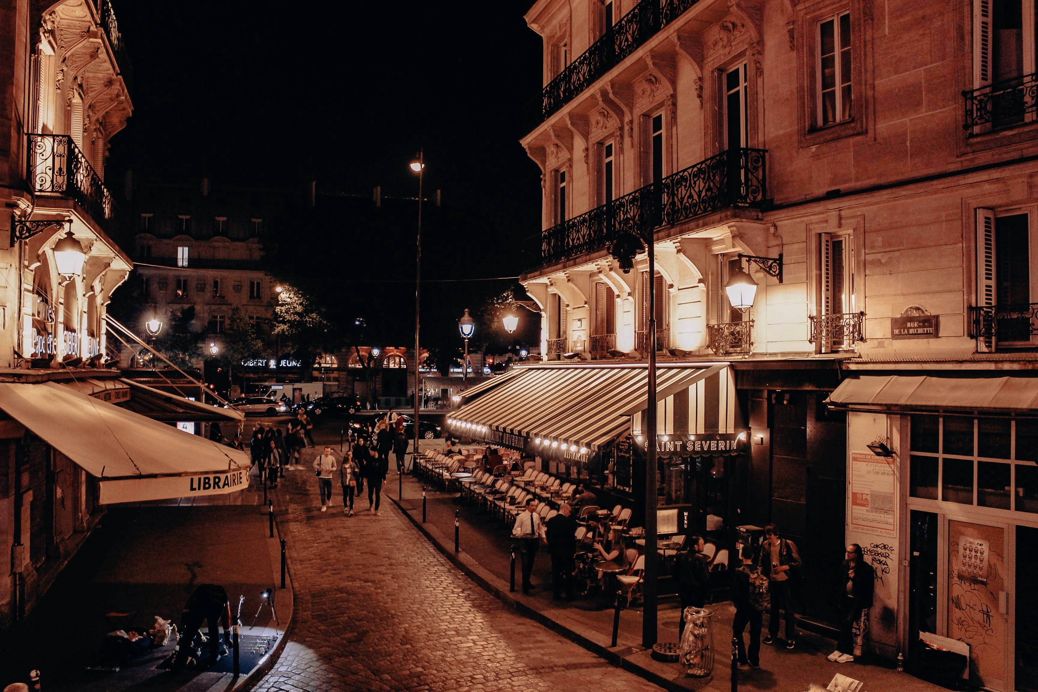 people walking on street near building during night time