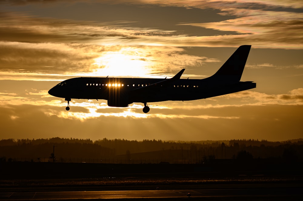 airplane flying over the city during sunset