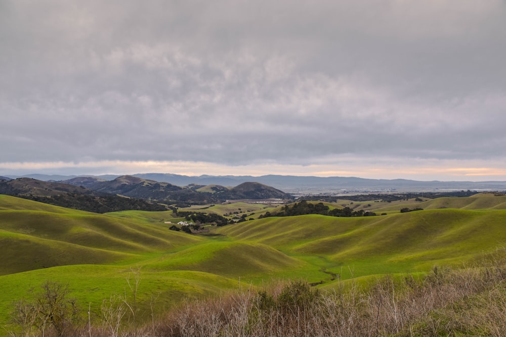 green grass field under cloudy sky during daytime