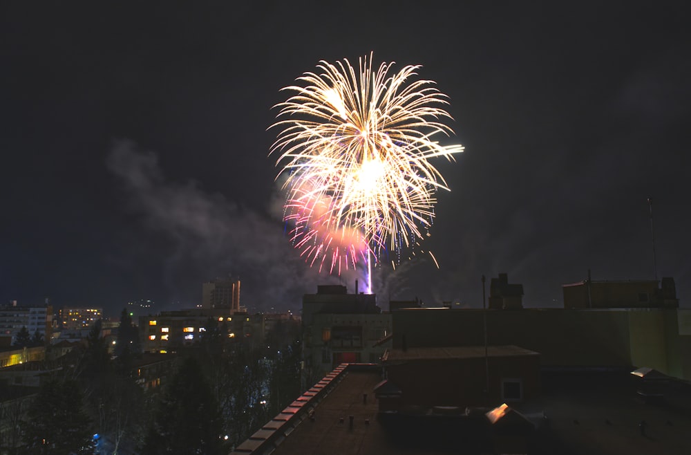 fireworks display over city buildings during night time