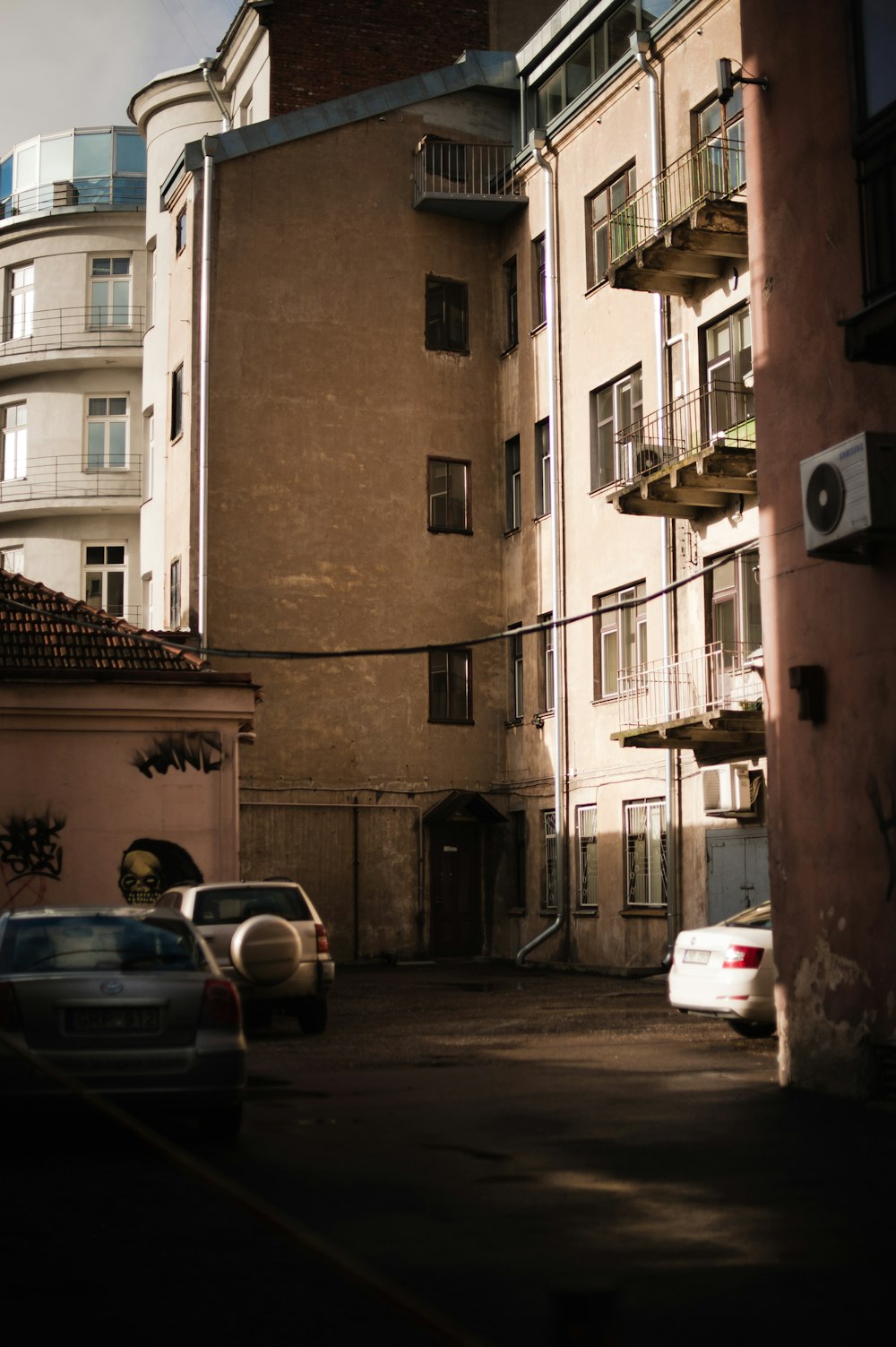 cars parked beside brown concrete building during daytime