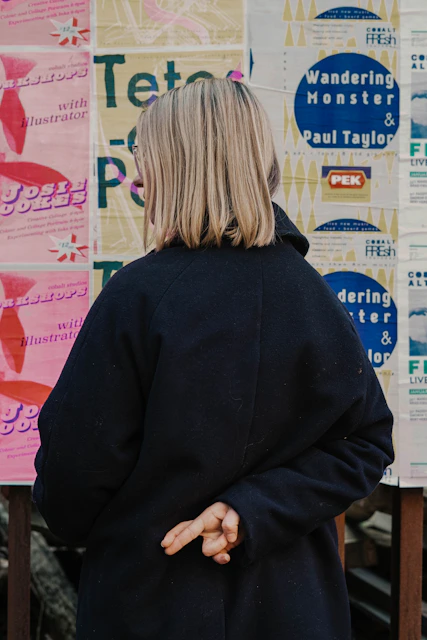 woman in blue hoodie standing in front of white and red kanji text signage