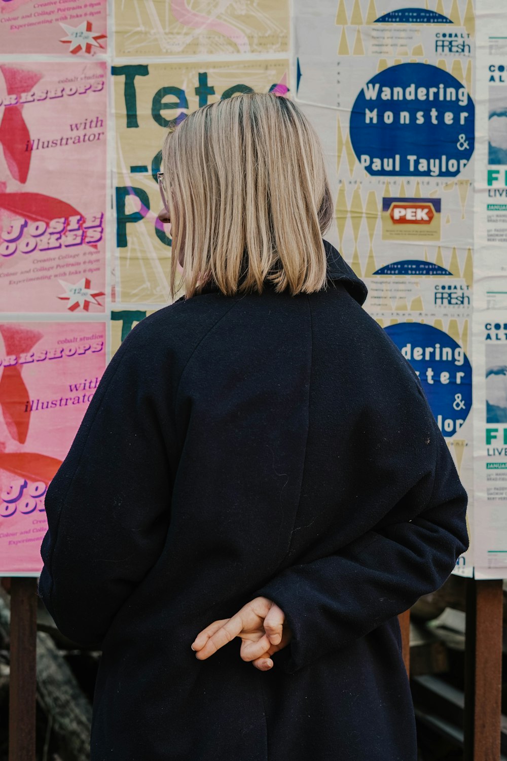 woman in blue hoodie standing in front of white and red kanji text signage