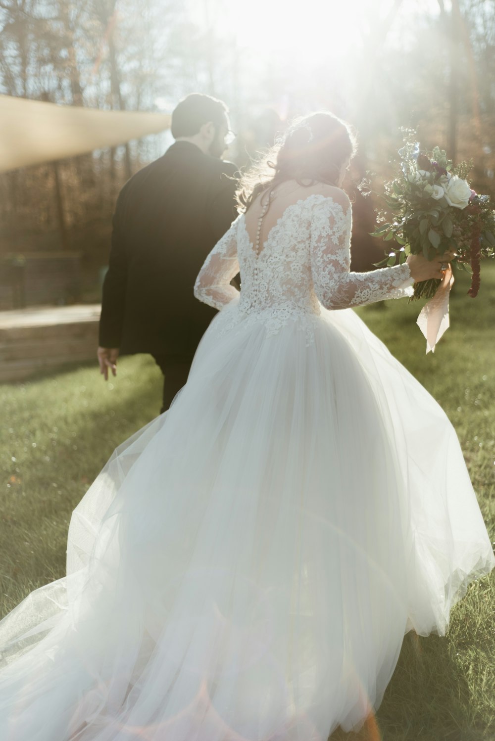 woman in white wedding dress holding bouquet of flowers