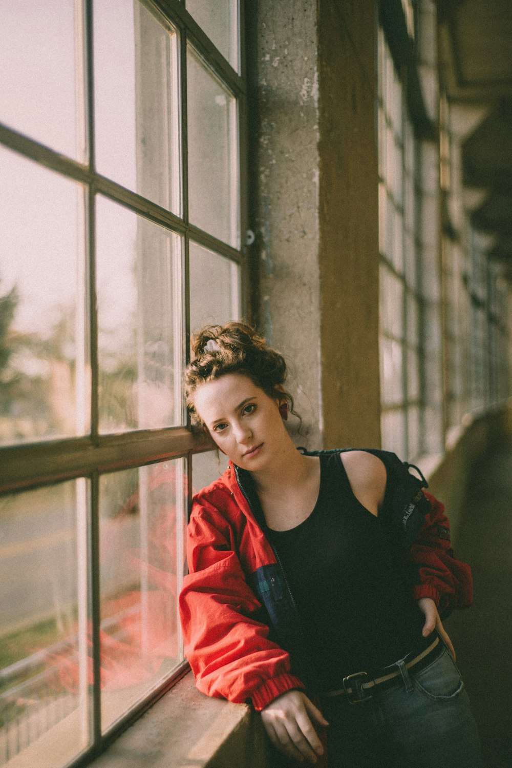 woman in black tank top standing beside window