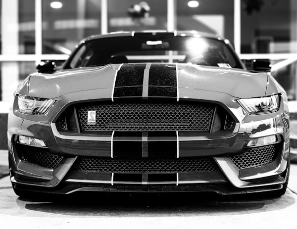 Black and White photo of a Ford Mustang Cobra front end in bright lights.by Obi - @pixel7propix