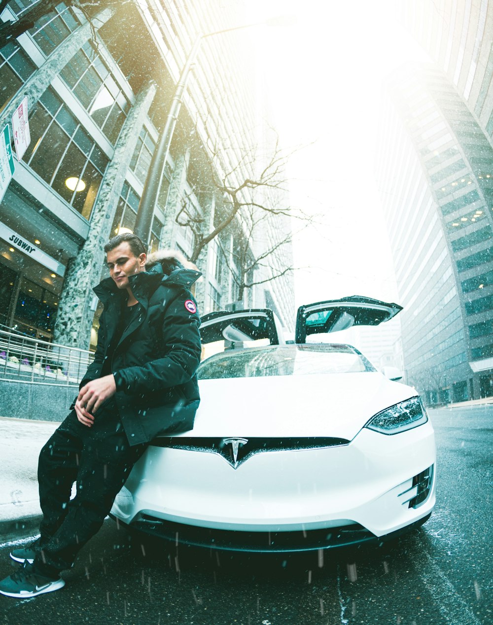 man in black jacket sitting on white car