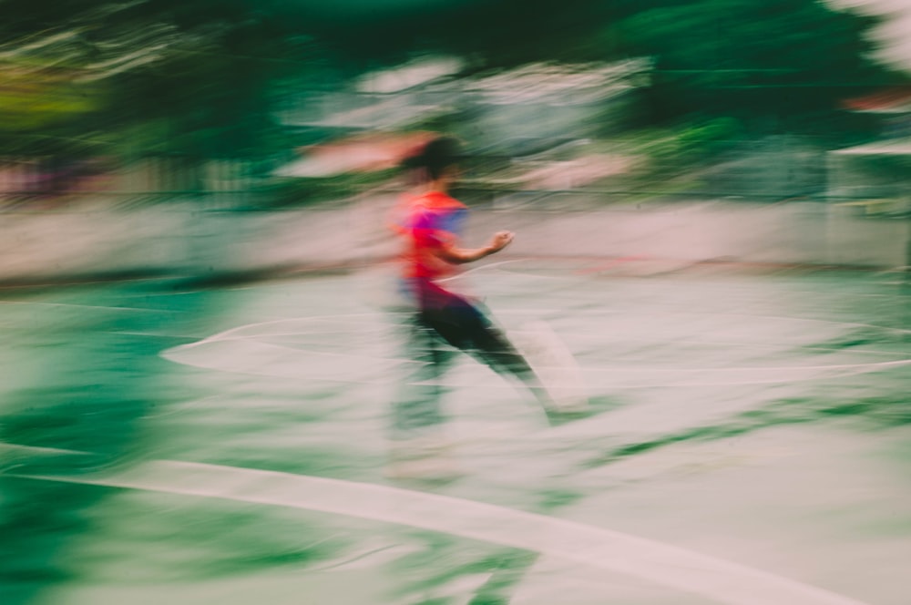 man in red shirt and black pants running on road during daytime