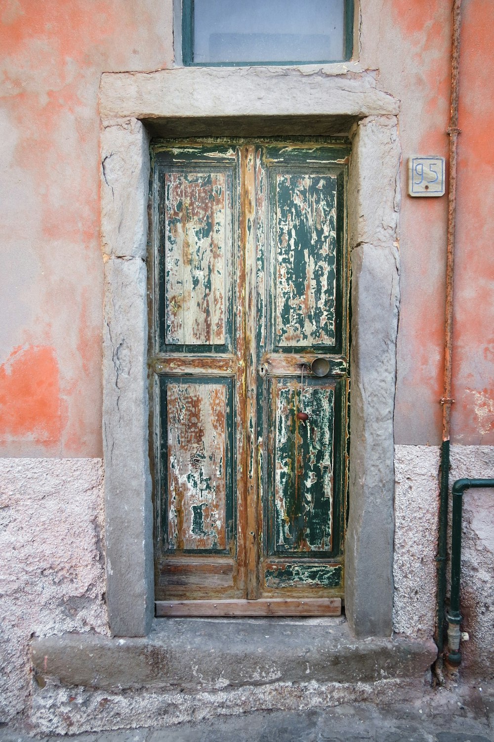 赤いコンクリートの壁に茶色の木製のドア