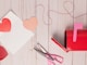 red and silver scissors on white wooden table