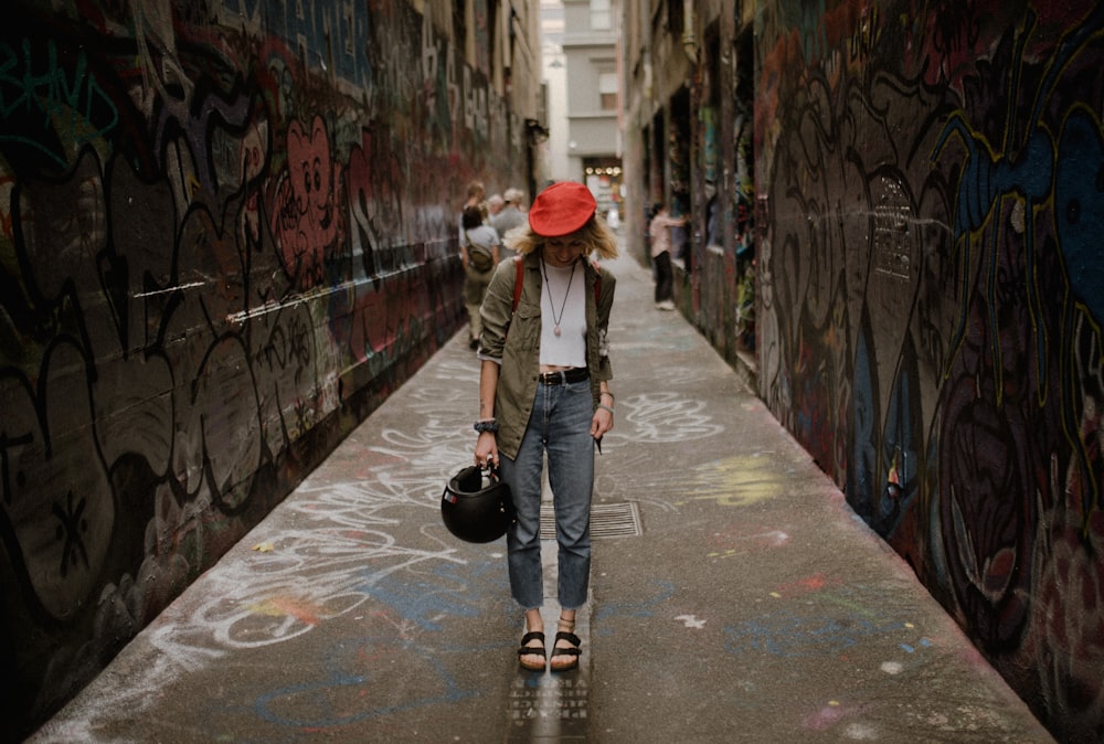 woman in brown jacket and black pants walking on sidewalk during daytime