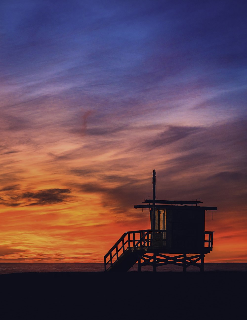 silhouette of lifeguard tower during sunset