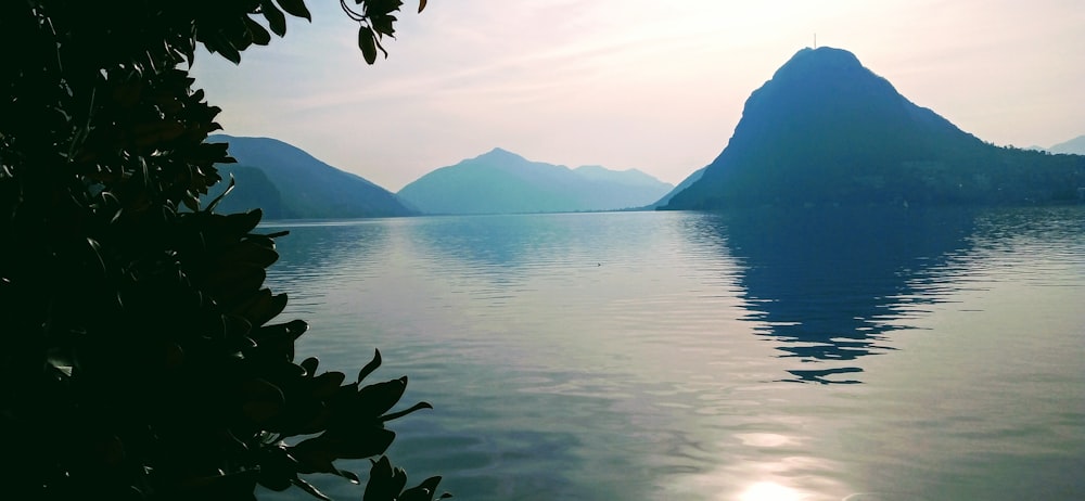 body of water near mountain during daytime