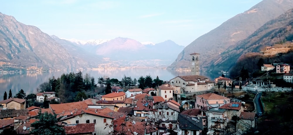 brown and white concrete houses near green trees and mountains during daytime