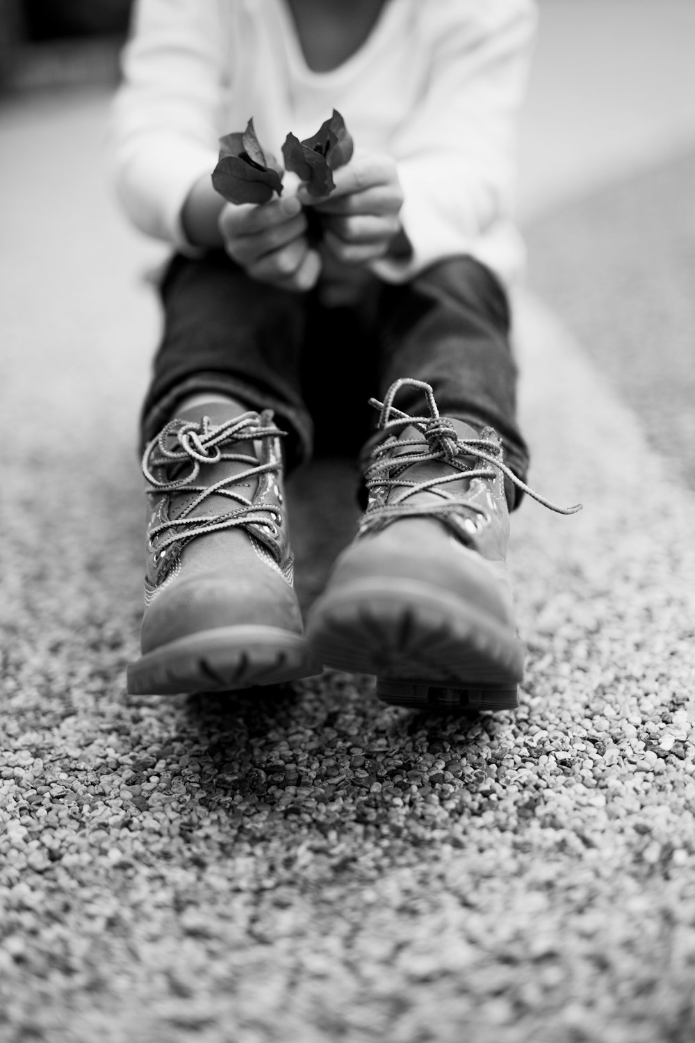 grayscale photo of person wearing hiking shoes