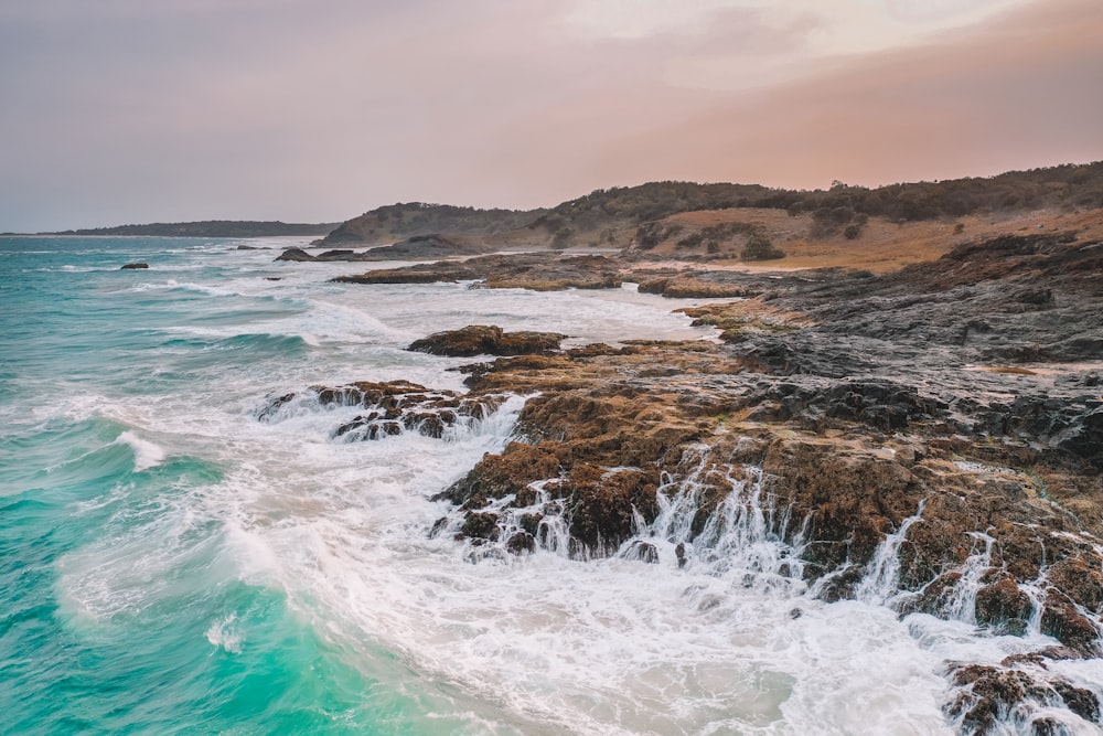 brown rock formation on sea during daytime