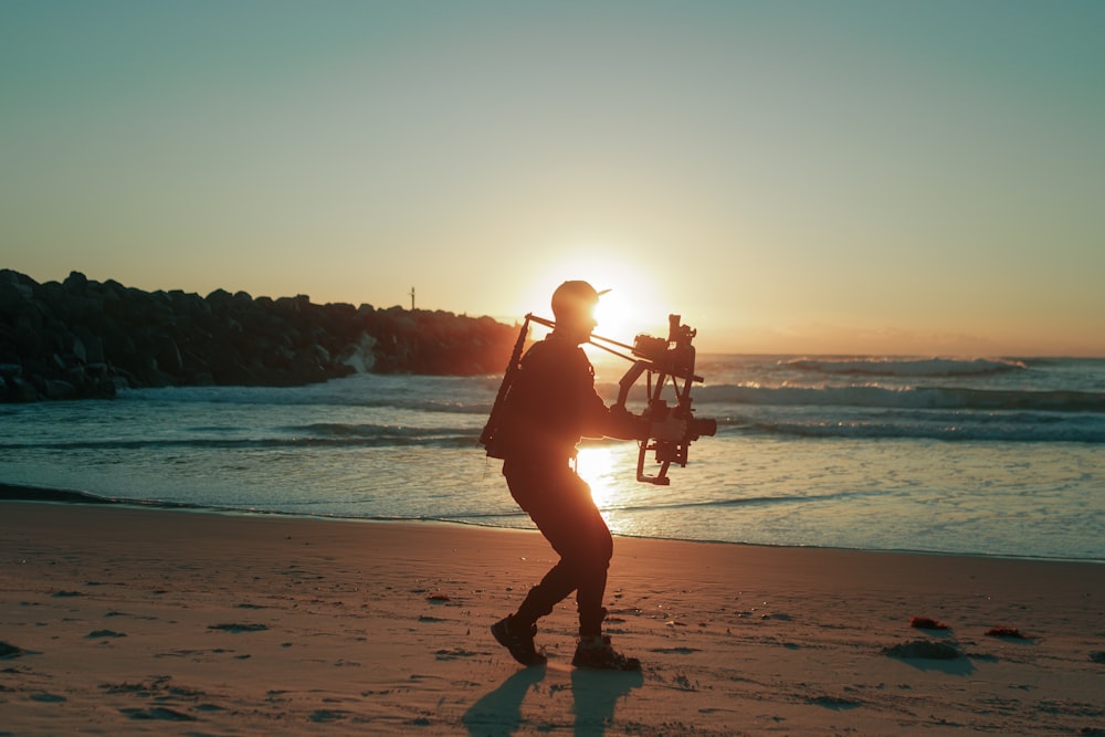 man in red shirt and black pants playing guitar on beach during sunset