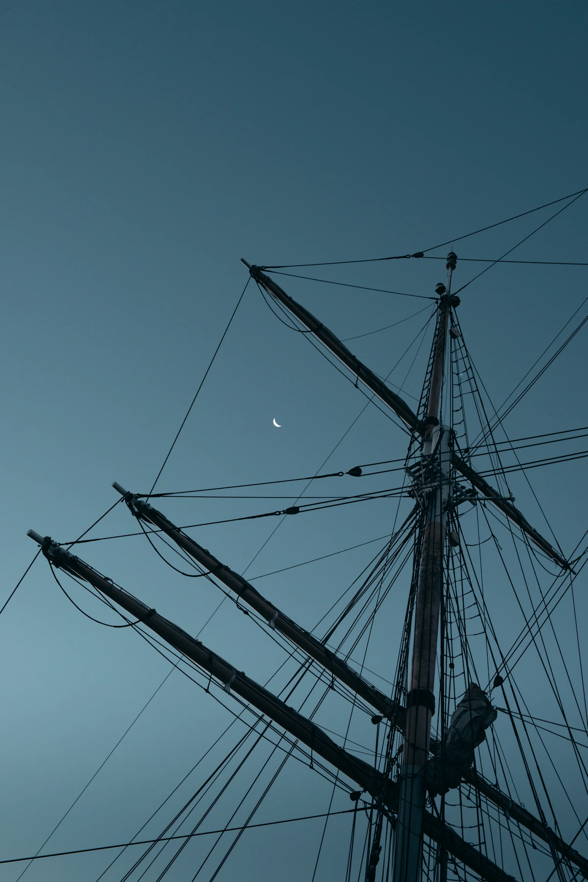 The masts and rigging of a large square-rigged sailing ship against the sky