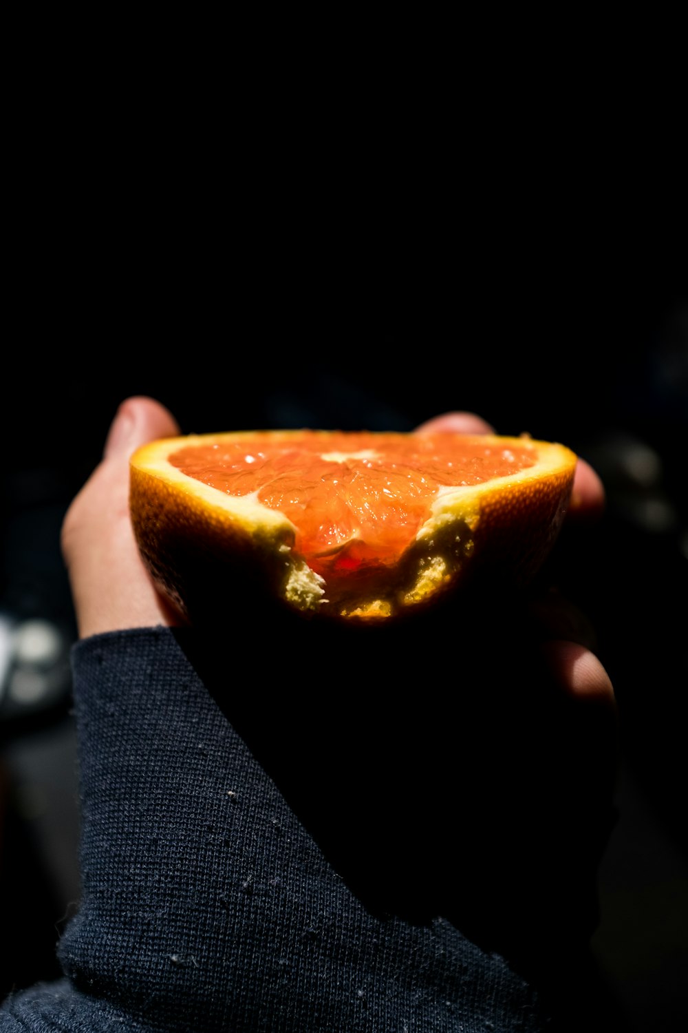 person holding orange fruit in close up photography